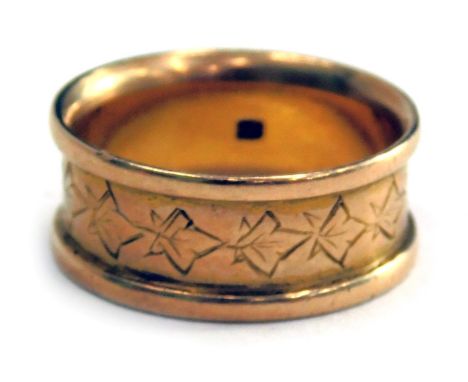 An Eastern wedding band, with shaped outer design, and central carved ivory leaves, with indistinct markings, yellow metal, r