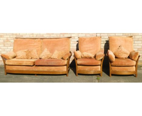 An Ercol elm sofa suite, comprising three seater sofa, and two single arm chairs, each with terracotta cushions, the sofa 82c