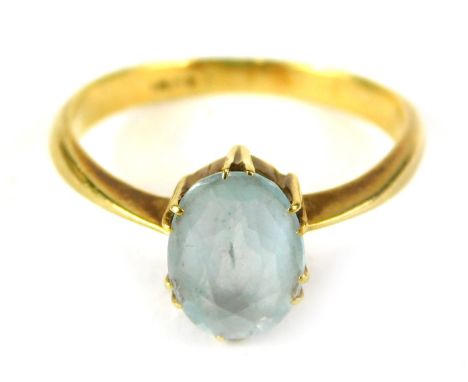 A blue topaz dress ring, with oval faceted stone, in six double claw setting, on a yellow metal band, stamped 18ct, ring size