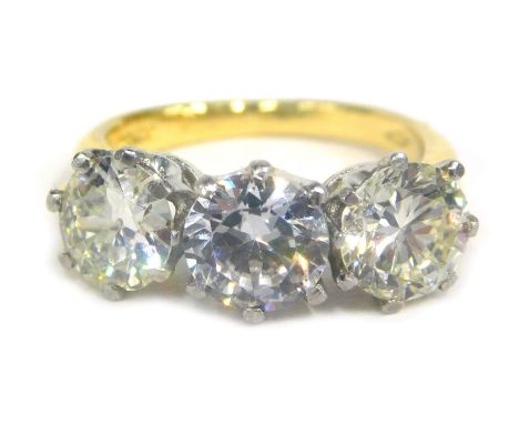 An 18ct gold three stone ring, set with two diamonds and one paste stone, the outer diamonds approx 6.29mm x 6.91mm, and 6.72