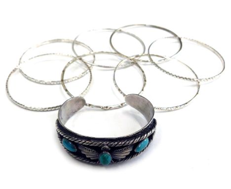 A group of bangles and bracelets, to include an eagle bangle, set with three turquoise stones, white metal, unmarked, and sev