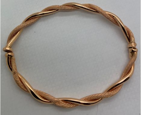 A twisted yellow metal bangle, tests as 9ct gold. Weight 4.8gm.Condition ReportFastener slightly loose.