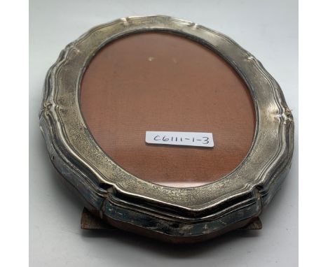 An oval silver easel back photo frame, Birmingham 1913 Turnbull Bros. 22.5cm l.Condition ReportSlight wood loss to easel and 