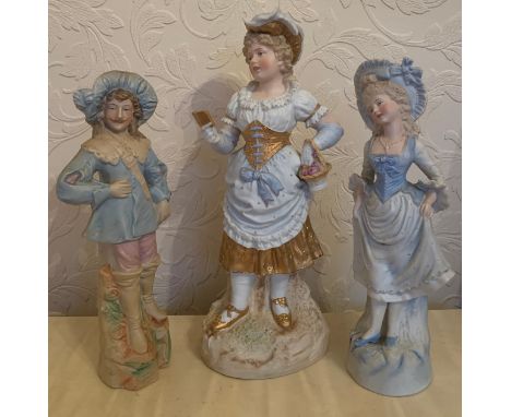 A pair of continental bisque figurines and a single figurine of a girl reading.Condition ReportGood condition.