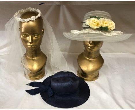 A wedding veil with floral head band, a ladies navy hat and a wedding hat with ribbon, bow and flower trim.Condition ReportFa