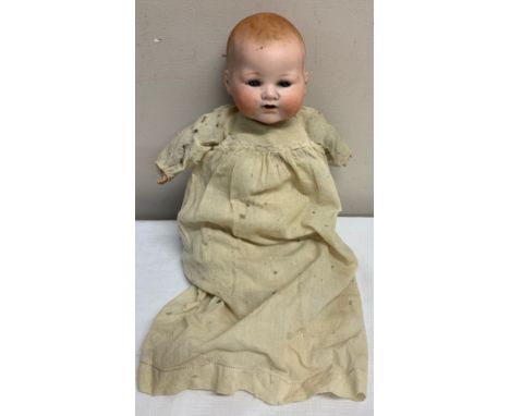 Bisque headed Armand Marseille doll with closing blue eye and open mouth with cloth body and plastic hands. Marked A M German