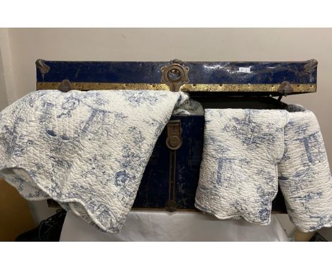 A large blue metal travel trunk. 92cm w x 43cms d x 46cms h together with a super king size French cotton bedspread and two p