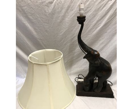 An African carved wood elephant table lamp with large cream shade. 63cm to light fitting.Condition ReportFairly good conditio