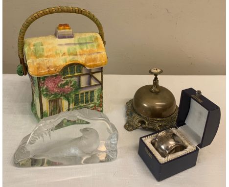 Miscellany to include Rubian Art house biscuit container, brass shop bell, hallmarked silver napkin ring and a Mats Jonasson 