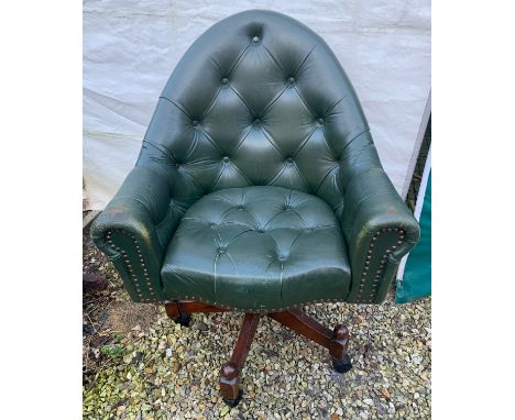 A green leather button back swivel tub armchair. Height to seat 48cm, to back 98cm, width 76cm.Condition ReportWear and crack