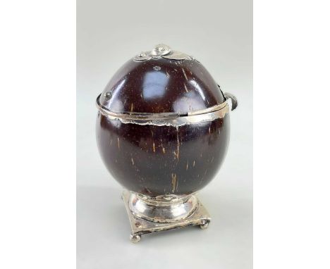 RARE 18TH CENTURY SILVER MOUNTED COCONUT TEA CADDY, foliate hinge strap and bracket, on lead filled square base raised on fou