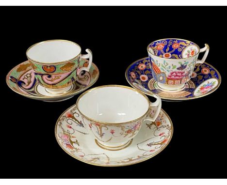 THREE SWANSEA PORCELAIN CUPS & SAUCERS comprising example with formal arrangement of gilded and iron red cornucopia alternati