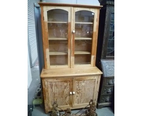 Stripped pine Cornish dresser, the arch glazed top enclosing three shelves over a cupboard base, width 41.5'