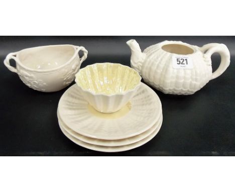 Six pieces of Belleek porcelain to include a moulded teapot (lacks lid), a sugar bowl moulded with vine leaves and berries, a