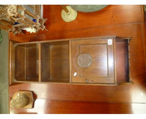 Oak Arts and Crafts wall hanging shelves with chequer band inlay and single cupboard with circular flower carving over a pipe