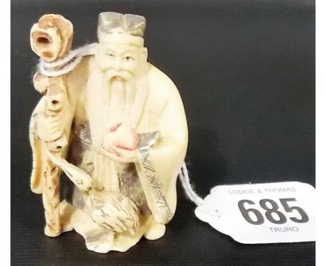 Japanese ivory netsuke carved and painted as a sage holding a staff, peach and with a bird at his feet, signed to the base, h