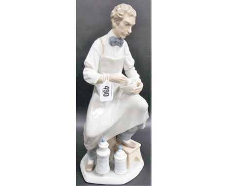 A Lladro porcelain group depicting a seated chemist with pestle and mortar, height 12.5'