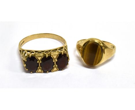 TWO 9CT GOLD AND GEM RINGS  Comprising; an oval garnet three stone ring, London 1969, size R, 3.2g gross; and an oval cabocho