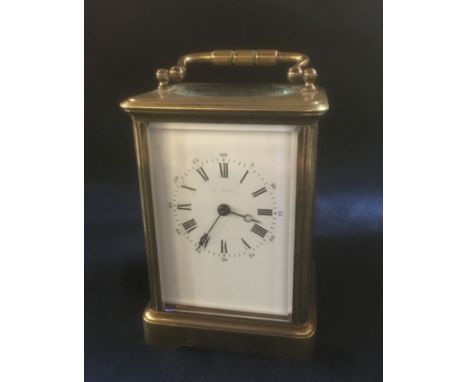 A BRASS CASED CARRIAGE CLOCK  the movement striking on a coiled gong, the enamel dial with Arabic and Roman numerals, indisti
