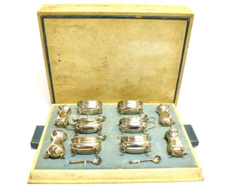 A SILVER TEN PIECE CRUET SET IN AN ART DECO CREAM CASE each with a shaped and moulded border and four leaf-trefoil and pad fe