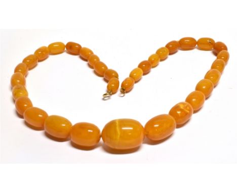 AN EARLY 20TH CENTURY AMBER BEAD NECKLACE the oval beads graduated approx. 32mm x 23mm to approx. 16mm x 10mm, strung on ligh