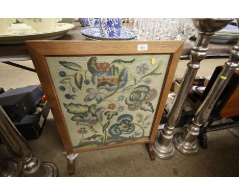 An oak framed embroidered firescreen