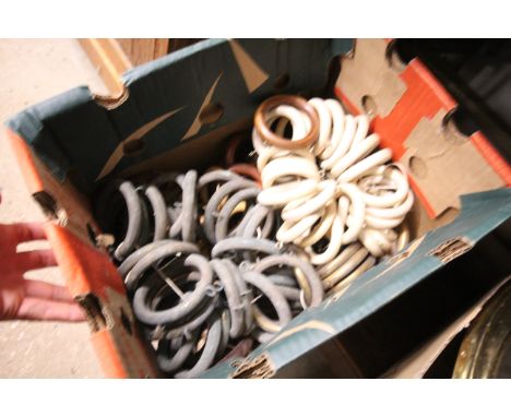 A box of various vintage brass and wooden curtain rings 