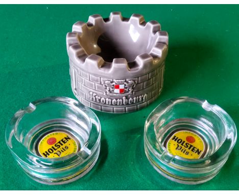 An unusual Kronenbourg Castle ashtray by Wade and a pair of Holsten Pils glass ashtrays.