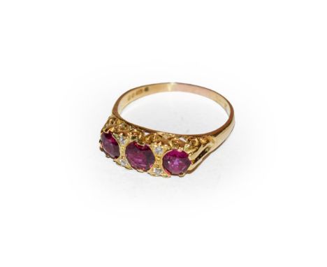 An 18 carat gold ruby and diamond ring, three graduated oval cut rubies with diamond accents, in yellow claw settings, to a t