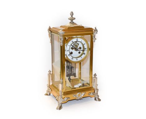 A brass four glass striking mantel clock, circa 1900, brass case with silvered mounts, four glass bevelled panels, raised upo