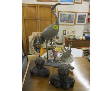 An early 20th century cast Japanese model of a stork, a white metal model of a cockerel and a pair of treen tribal busts 