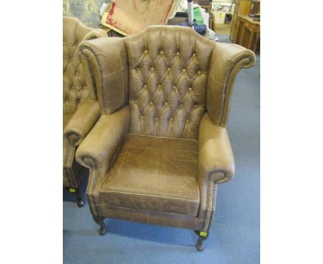 A new brown leather, button, winged back armchair 