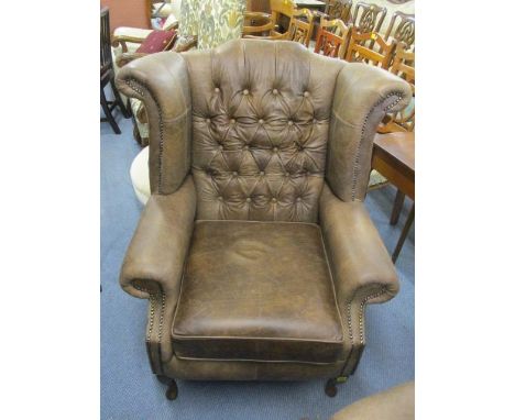 A new brown leather button, winged back armchair 