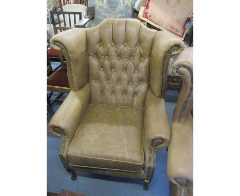 A new brown leather button, winged back armchair 