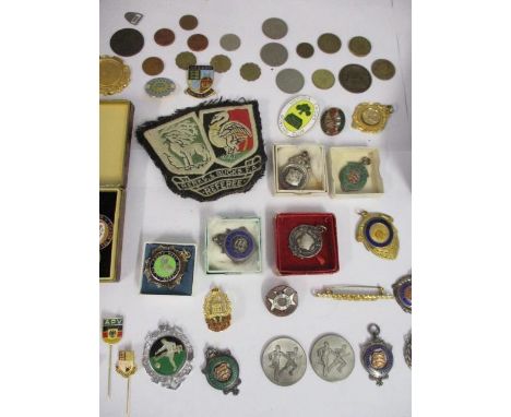 A mixed lot of silver and other metal badges, stick pins, a cloth badge and mixed coins 