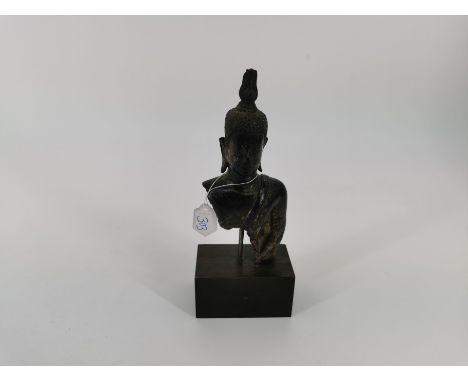 BUDDHA, Bronze, braun patiniert und mit Resten von Goldlack, Thailand, 19./20. Jh.; auf Holzpostament montiertes Fragment ein