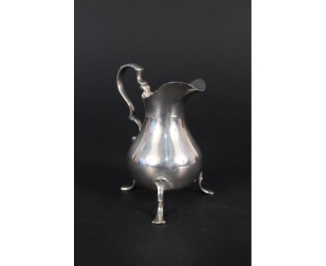 A silver cream jug with wavy rim on three legs, hallmarked Birmingham 1897 by Haseler Brothers