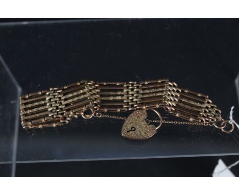 A 9ct gold gate bracelet with engraved detail to interlocking links with a 9ct gold heart shaped padlock clasp with engraved 