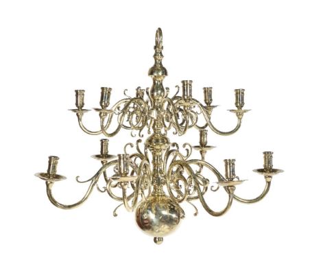 A Dutch or English brass twelve light chandelier in early 18th century taste, later 19th century, the scrolled arms arranged 