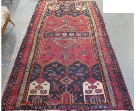 Middle Eastern design red and blue ground carpet, the central panels with floral motifs, flanked by geometric designs. 280 x 