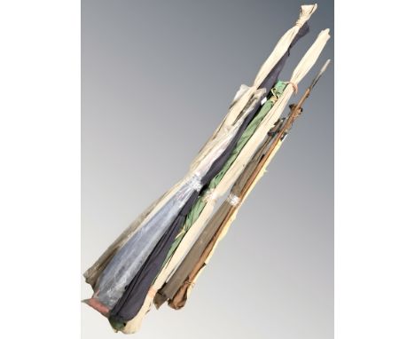 A group of vintage fishing rods in canvas slip covers.
