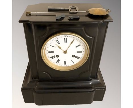 A black slate eight day mantel clock with enamel dial, with pendulum and key, height 27 cm. (as found)