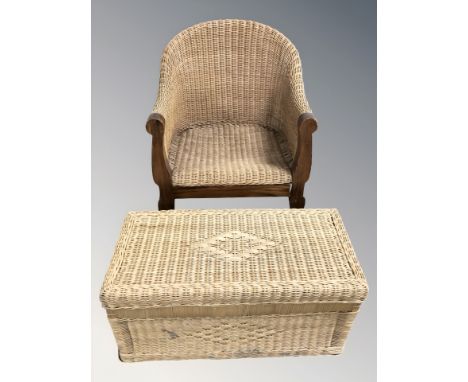 A wooden framed wicker armchair and a wicker hamper.