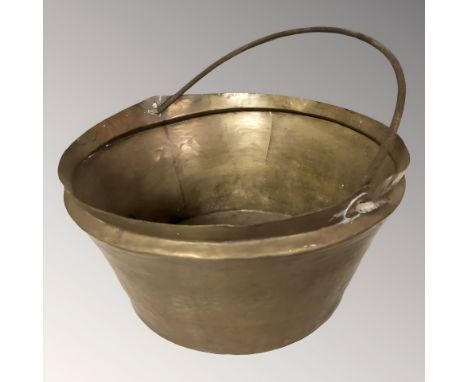 A brass swing handled cooking pot, height 21 cm excluding handle.
