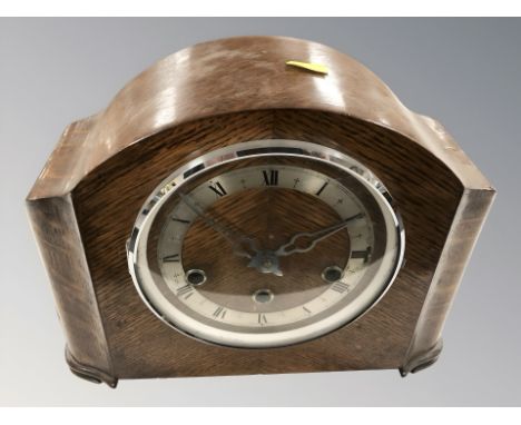 An Art Deco oak eight day mantel clock, with pendulum and key, height 23 cm.
