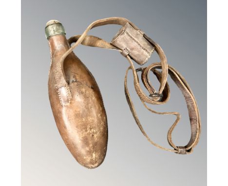 A glass powder flask, covered in stitched chestnut-brown leather with sling, the flask 24cm long.  