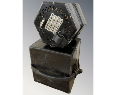 An early 20th century twenty four button concertina, with ebony fret work end pieces and black leather bellows, missing maker
