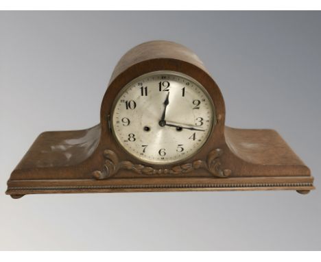 An early 20th century carved oak eight day mantel clock, width 61 cm.
