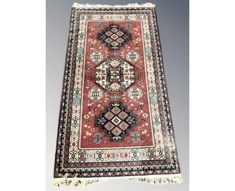 A machine made rug of Persian design, 213 cm x 111 cm.
