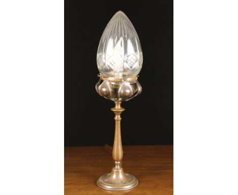 An Art Nouveau Bronzed Table Lamp. The cut glass shade raised on a petalled holder above a slender baluster stem and round fo